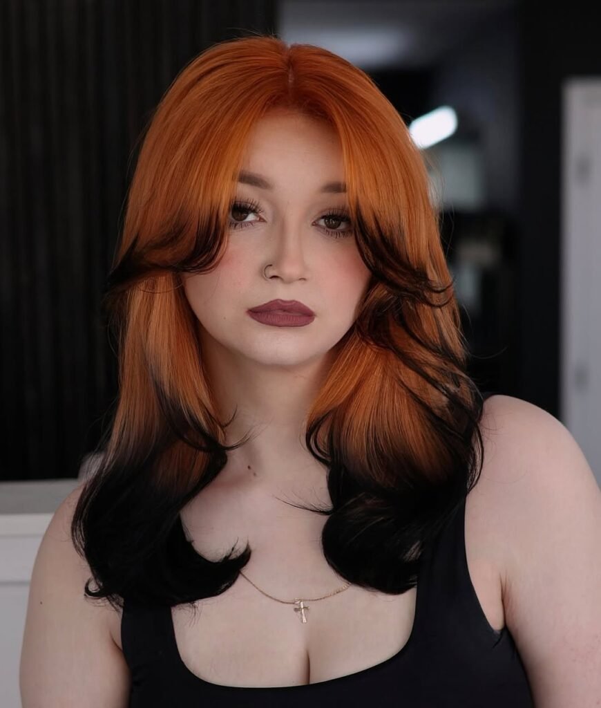  Woman with striking burnt orange and black contrast hair — a dramatic and fiery look perfect for Fall Hair Colors.