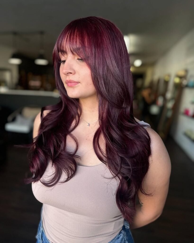 Deep burgundy hairstyle with bangs, a bold choice for fall hair colors.