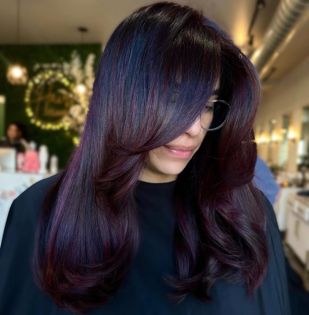 Woman with sleek and layered plum-colored hair — a cool and elegant pick for Fall Hair Colors.