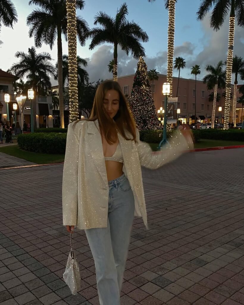 Woman in a lace-up sheer white top with a denim mini skirt and red heels — a flirty and fresh Night Out Outfit.