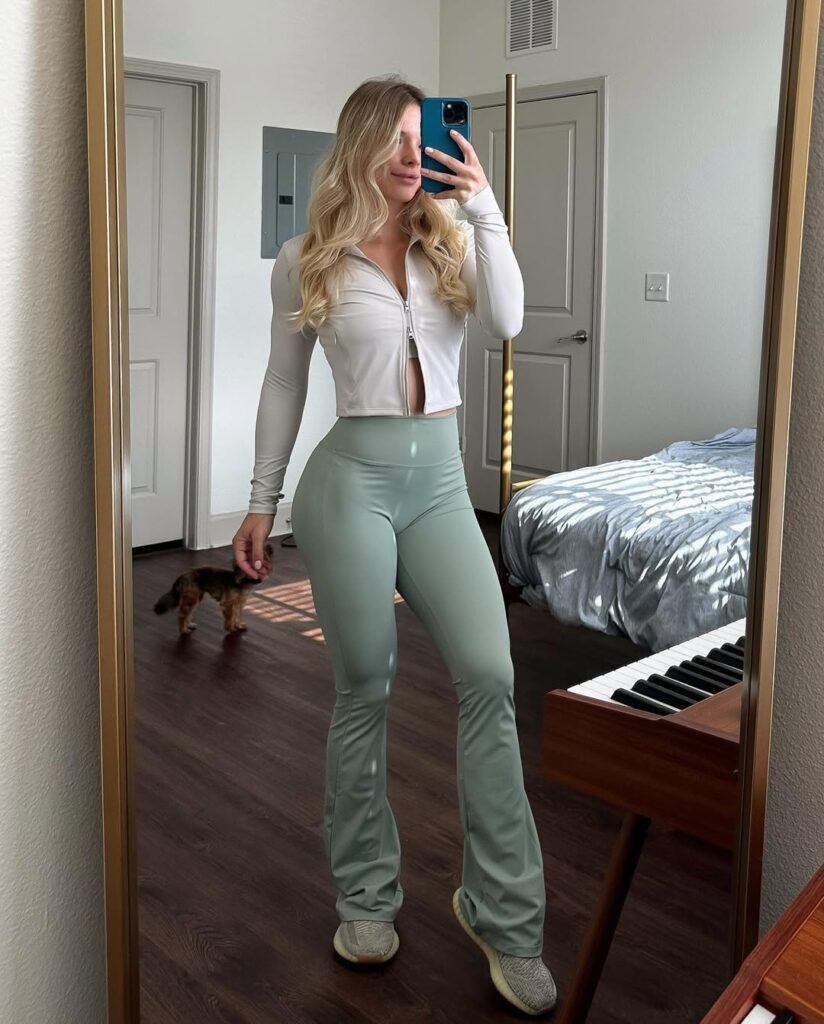Gym outfit inspo with a light zip-up long-sleeve and mint green flare leggings, taken in a mirror selfie.