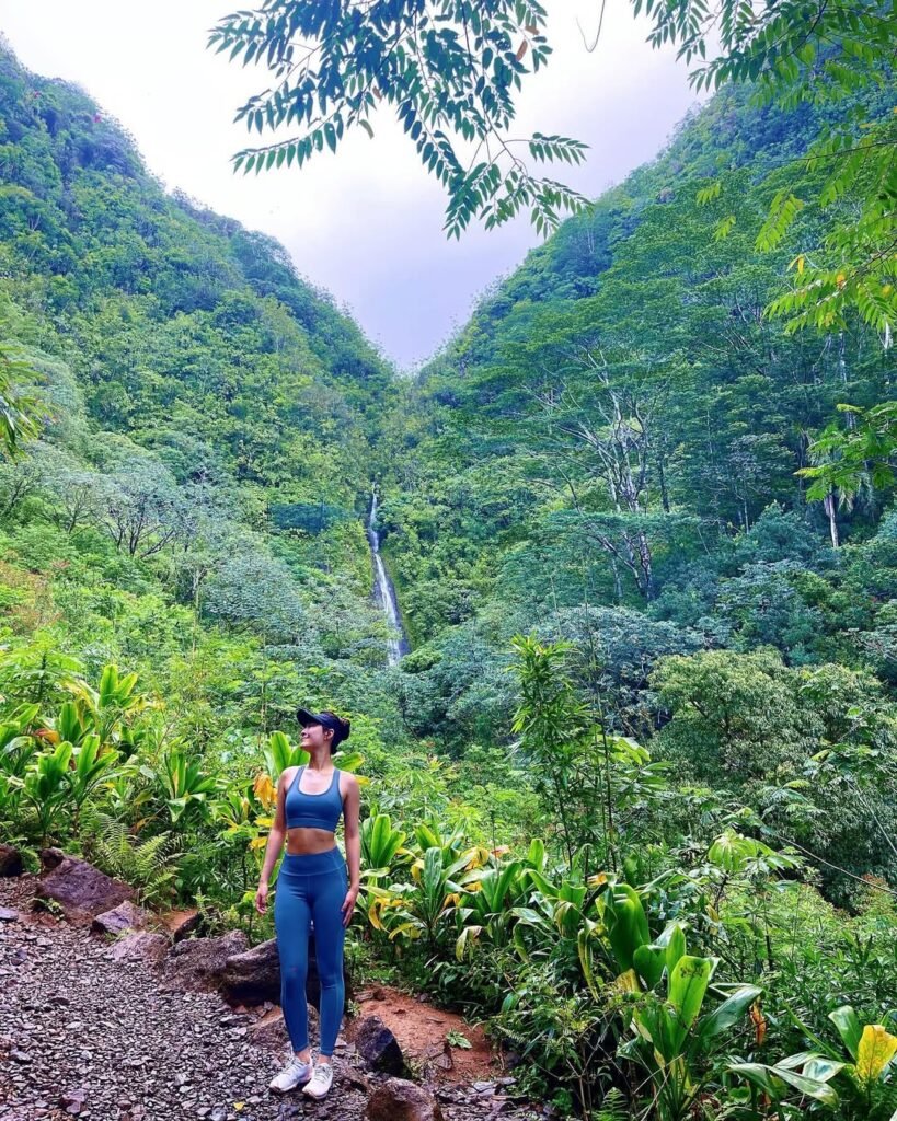 Gym outfit inspo captured on a scenic hike, featuring a matching blue workout set and black cap.