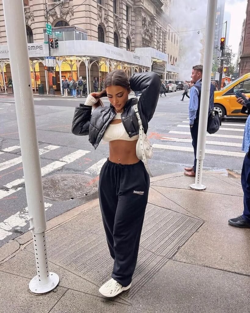 Cozy city outfit inspo with a cropped knit sweater, puffer jacket, and joggers.