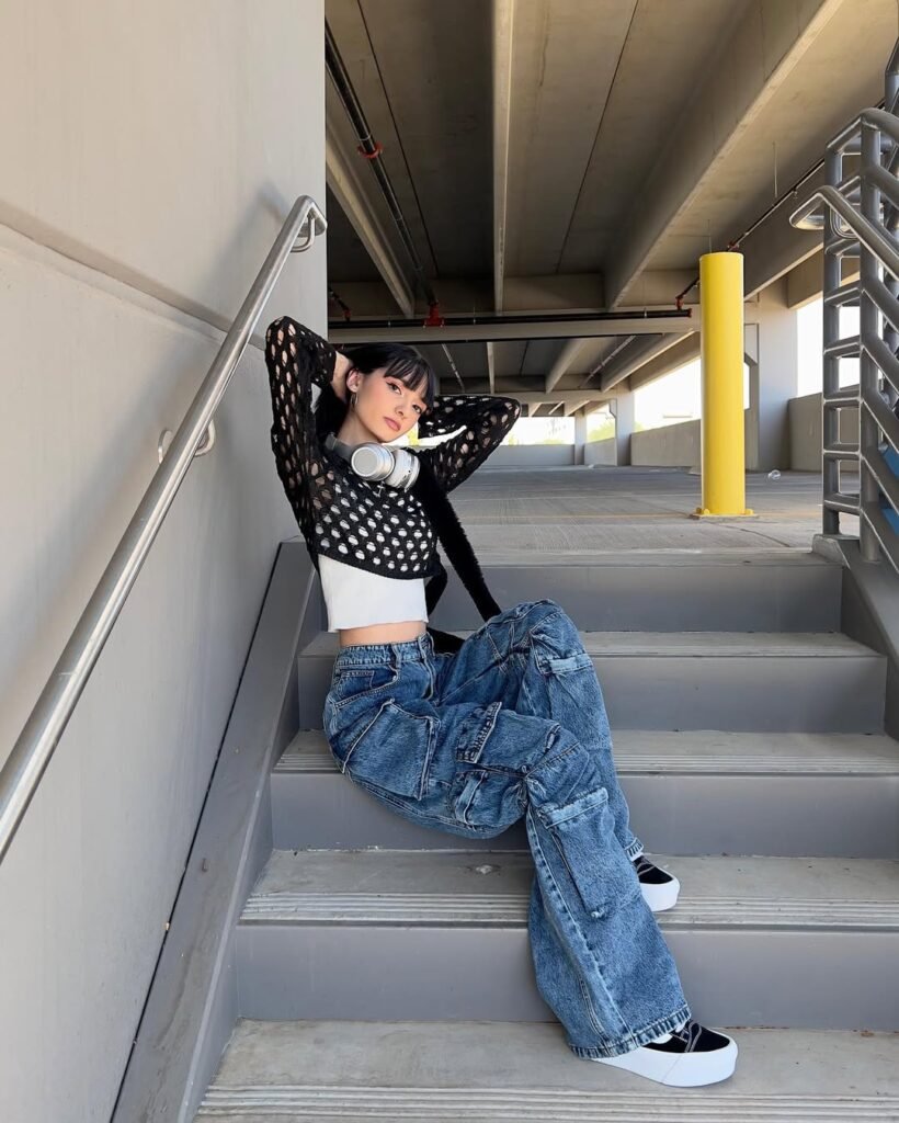 Edgy outfit inspo featuring a black mesh top, white crop tank, and oversized cargo jeans.