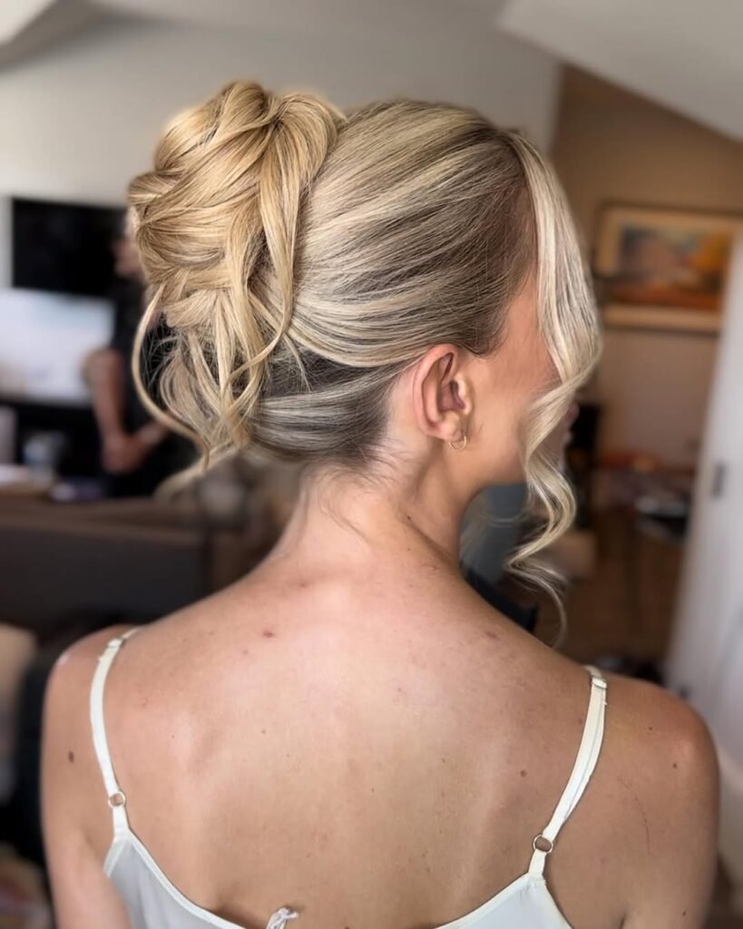 Elegant updo with volume and soft curls for a chic look.