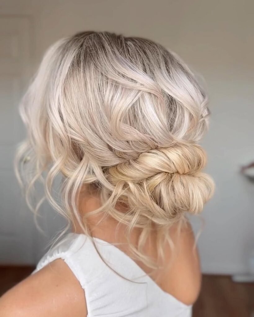 Messy blonde low bun with waves – elegant and romantic hairstyle.