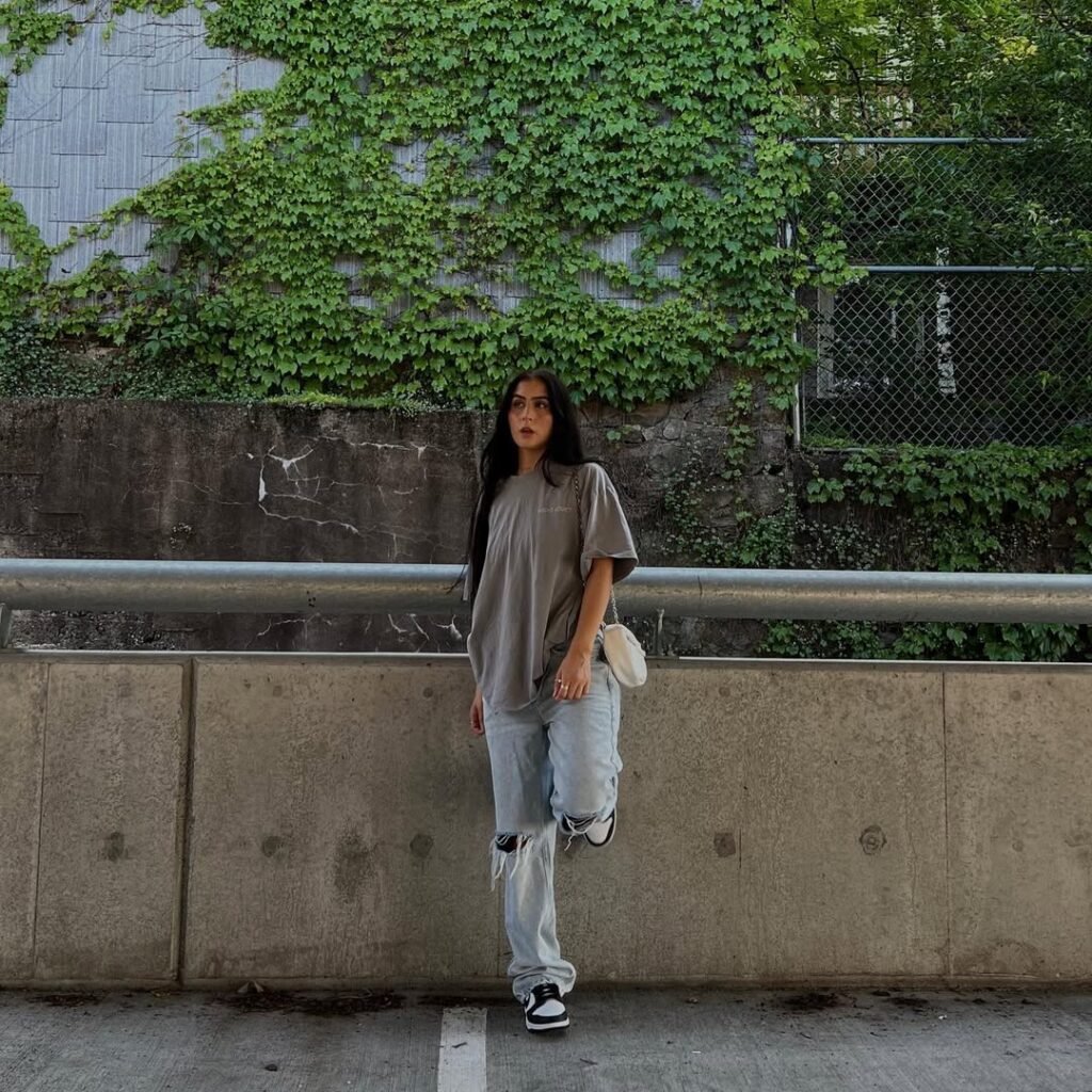 Relaxed outfit inspo featuring an oversized gray tee and ripped jeans with sneakers.