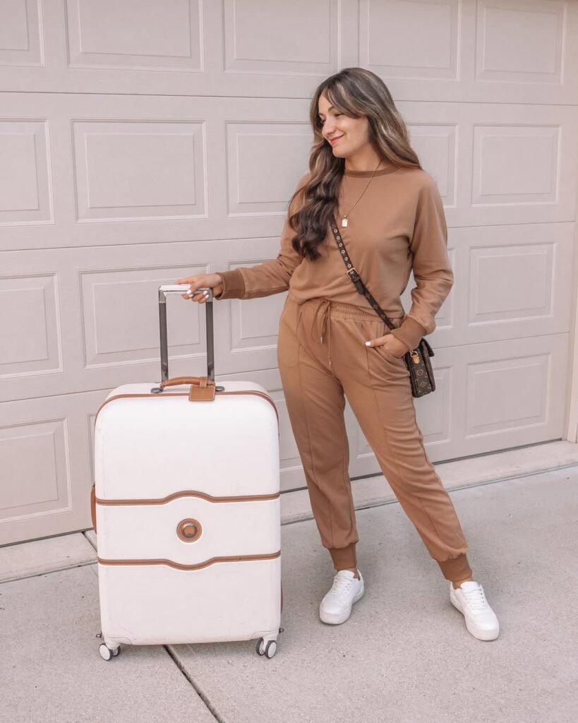 Relaxed airport outfit with a monochrome brown sweatsuit and white sneakers – perfect for long travel days.