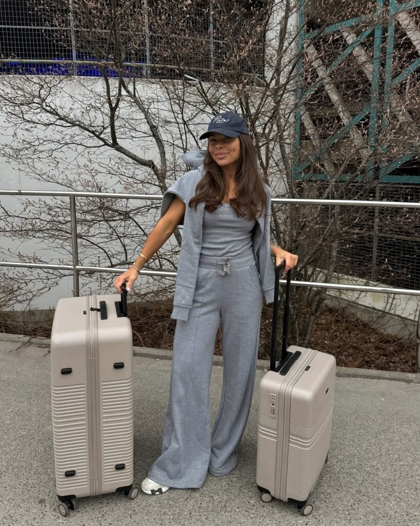 Casual chic gray loungewear set styled with a cap and sneakers – effortlessly cool airport outfit.