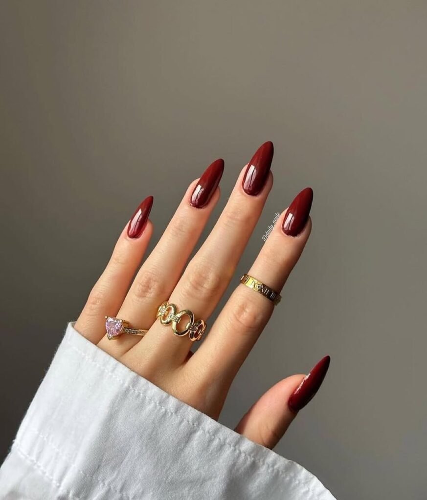 Elegant glossy maroon Fall Nail Colors on almond-shaped nails.