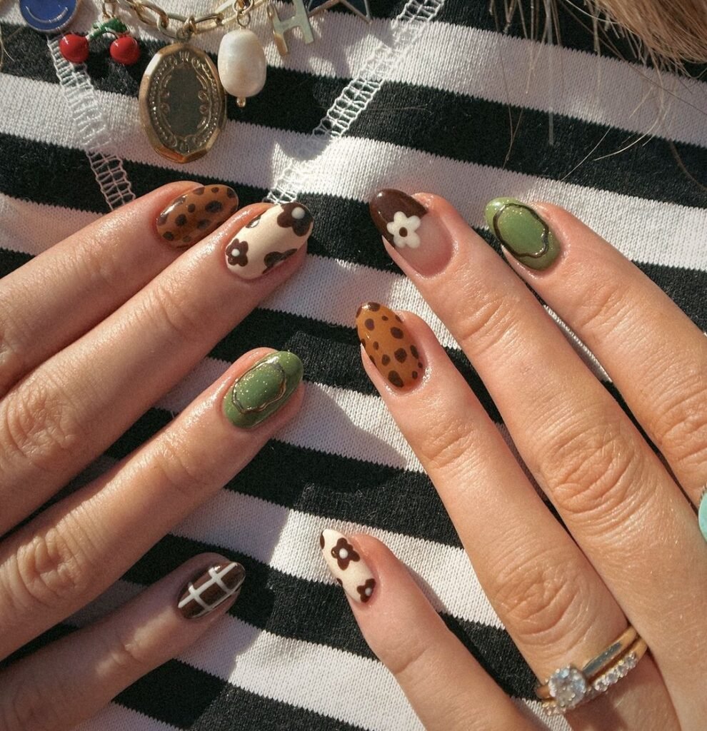 Trendy earthy Fall Nail Colors with green, brown, and floral nail art on a striped background.