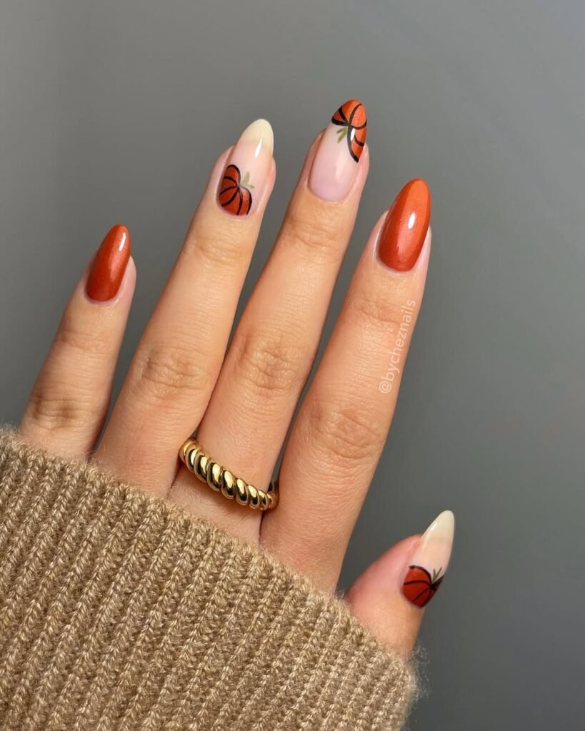 Orange metallic nails with pumpkin nail art — festive and fun for a fall Night Out Outfit.