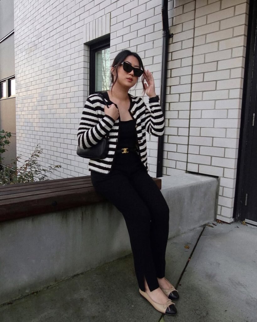 Classic black and white striped cardigan outfit paired with black trousers and flats.