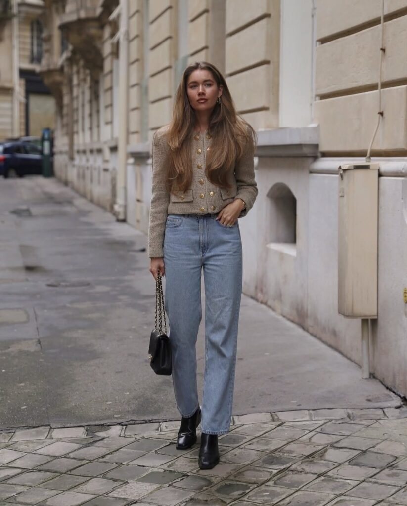 Classic cardigan outfit featuring a fitted beige cardigan with gold buttons, light-wash jeans, and ankle boots.

