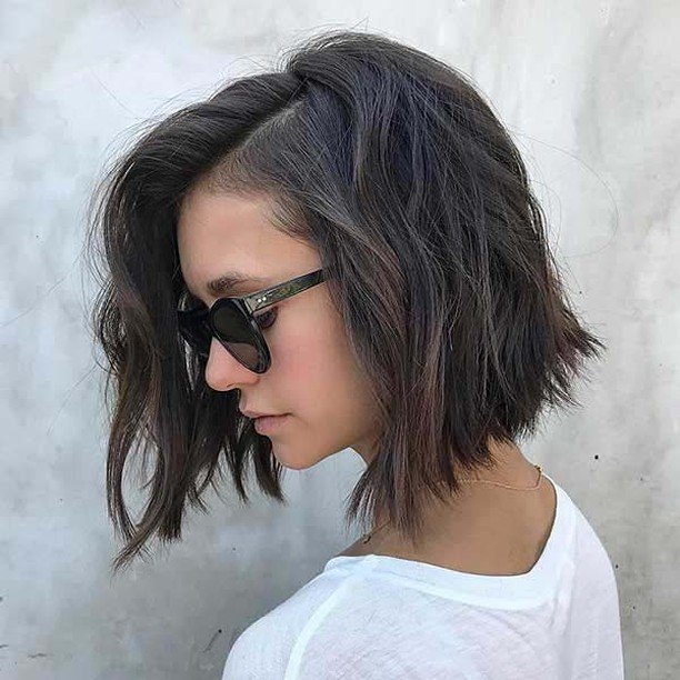 Messy angled bob with natural black tones and sunglasses – cute hairstyles for short hair.
