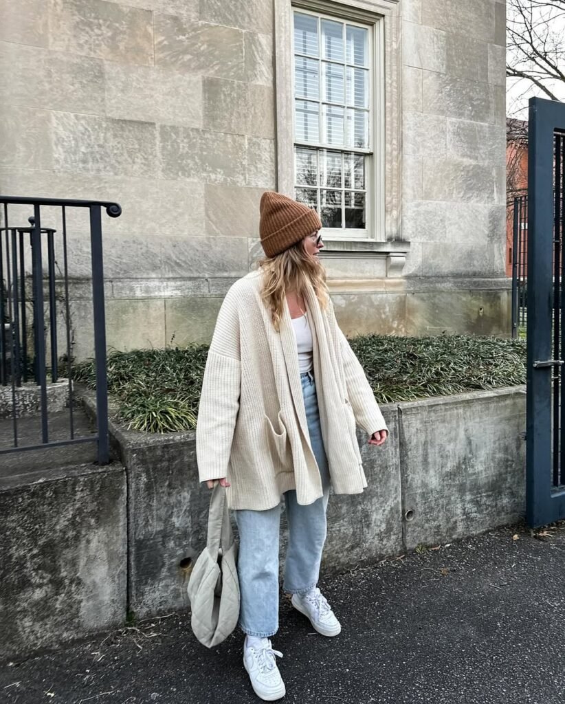 Oversized beige cardigan outfit styled with a beanie, white tank top, and relaxed denim.
