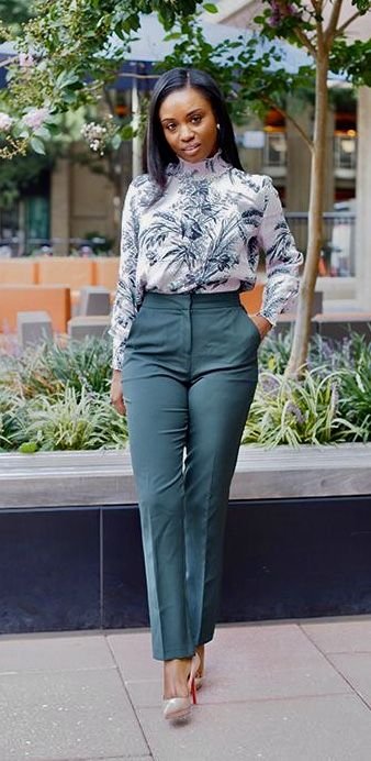 Stylish work attire with a printed high-neck blouse tucked into dark green tailored pants, completed with nude pumps for a fresh and elegant office ensemble.