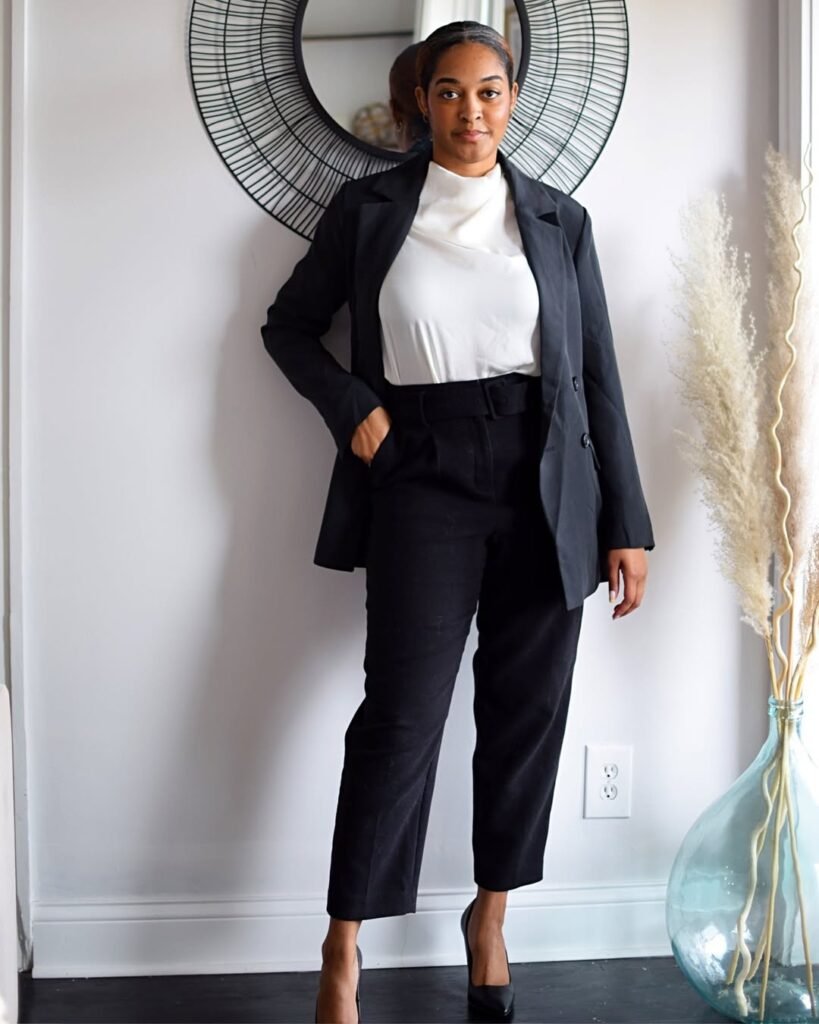Stylish work attire with a black blazer and trousers, styled with a high-neck white blouse and black pumps for a classic business formal outfit.