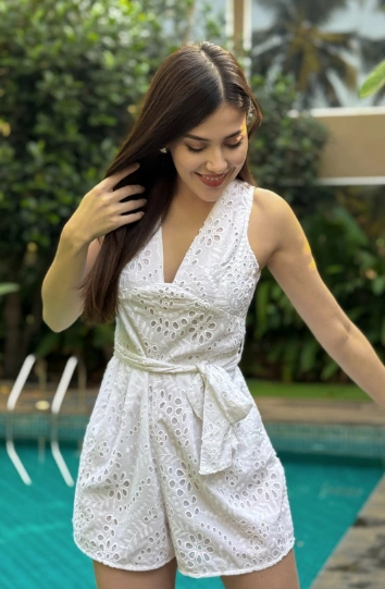 White eyelet romper with a waist tie, worn near a pool with minimal accessories — effortlessly stylish for outfit ideas summer.