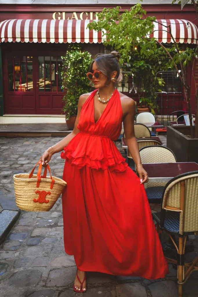 Bold red halter maxi dress with ruffle detailing, styled with statement sunglasses and a straw bag — a striking look for outfit ideas summer café outings.