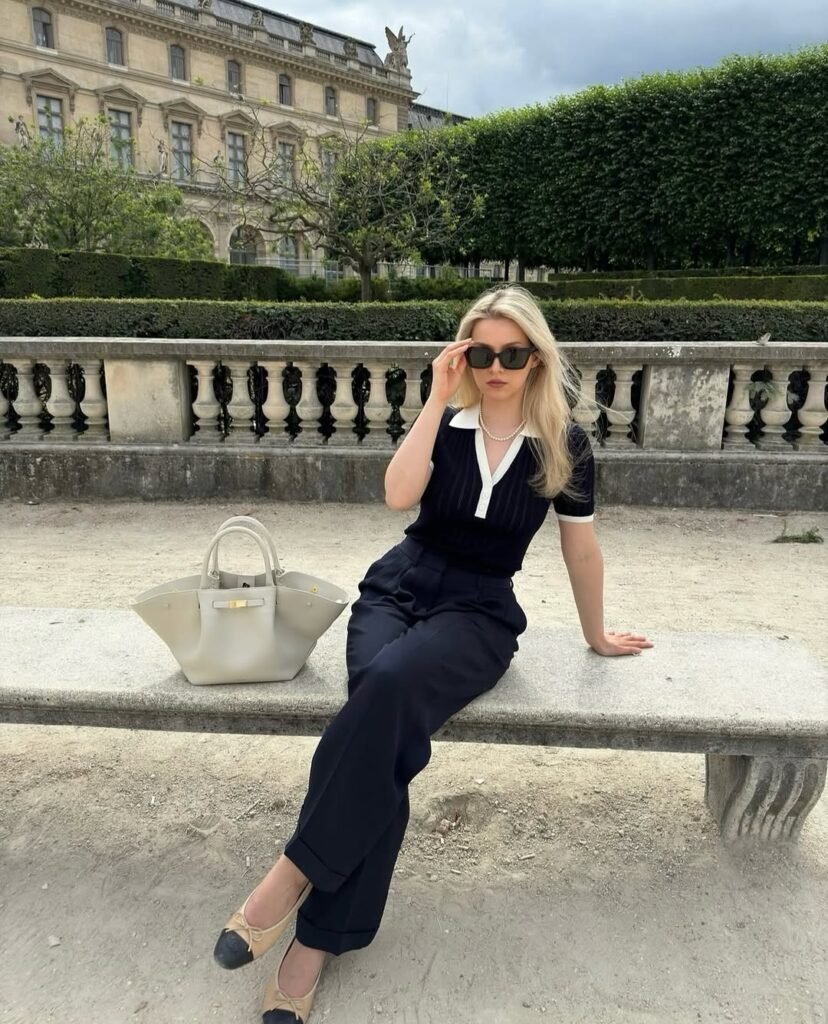 Polished stylish work outfit featuring a black-and-white top paired with navy trousers.