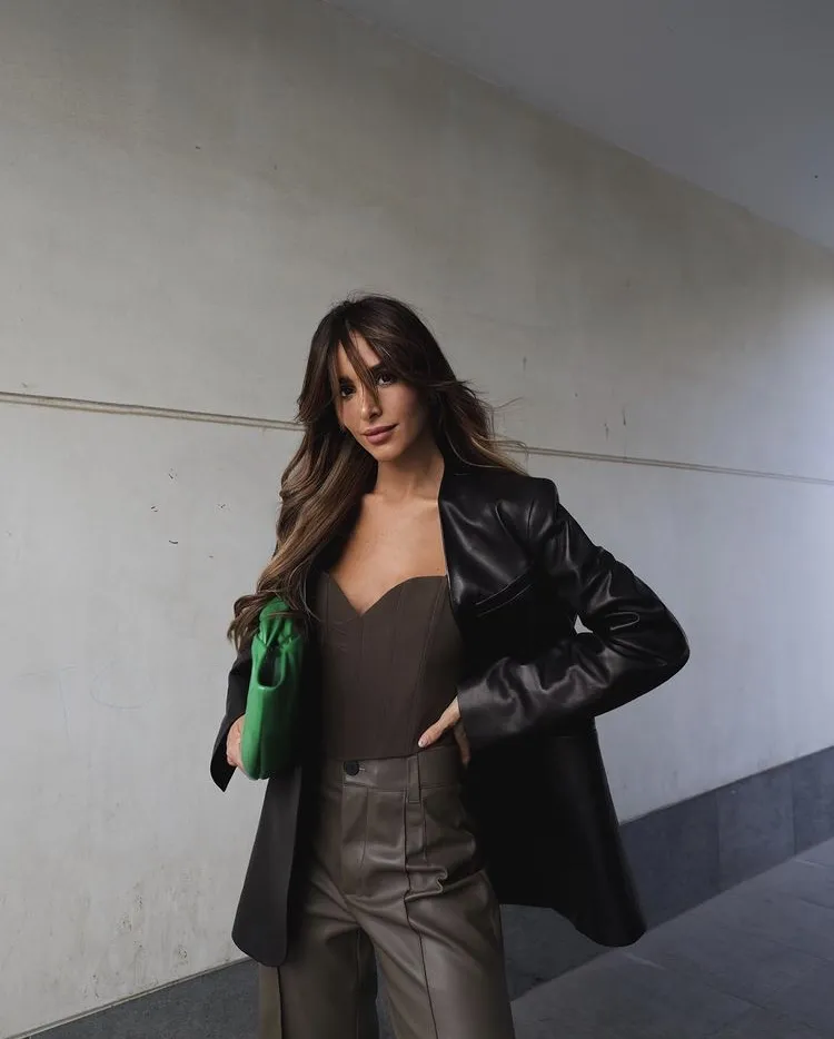 Chic Leather Blazer look styled with a brown bustier top, high-waisted brown leather pants, and a bold green clutch.