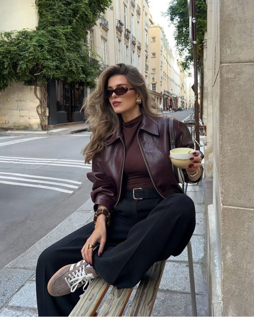 Elegant look with a brown Leather Blazer layered over a dark top and black trousers, styled with retro sunglasses and sneakers for a coffee-on-the-go moment.