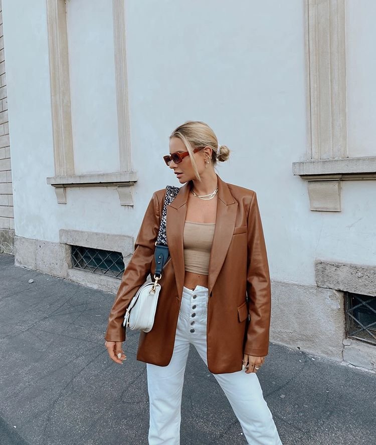 Sleek brown Leather Blazer look with a nude crop top and high-waisted white pants, accessorized with cat-eye sunglasses and a designer bag.