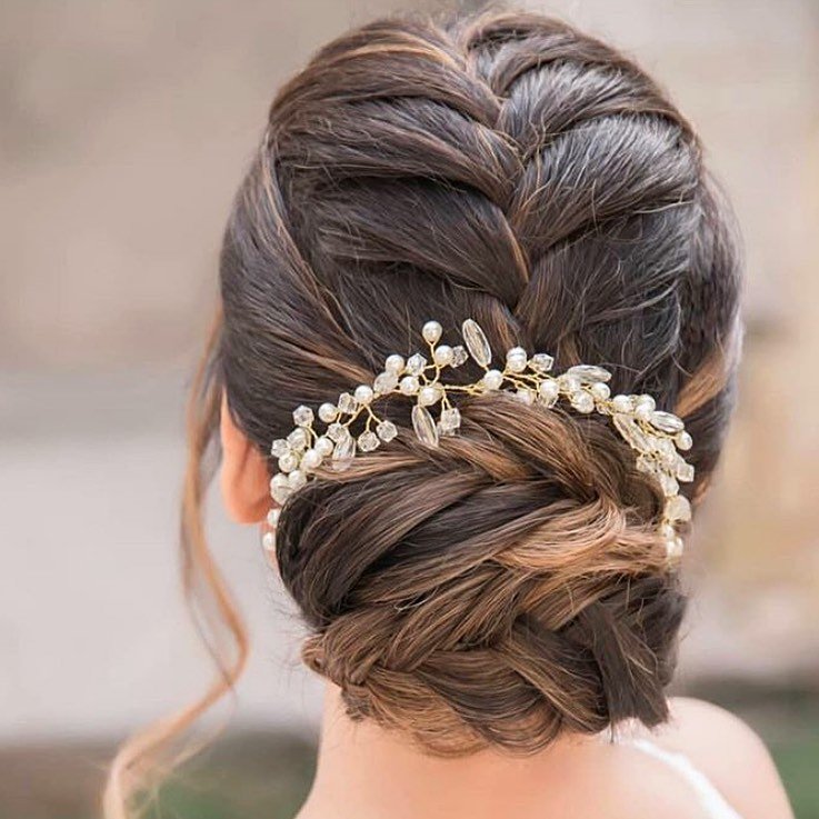 Elegant braided updo adorned with pearl accessories — a timeless hairstyle perfect for formal events.

