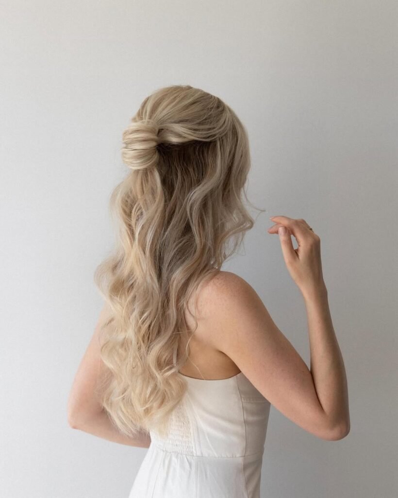Half-up twisted knot with flowing waves – soft elegant hairstyle.