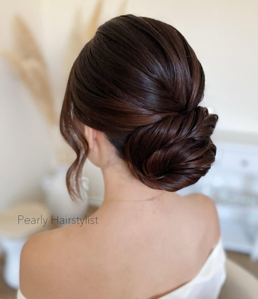 Elegant hairstyle showcasing a smooth, low bun with a polished, twisted finish.