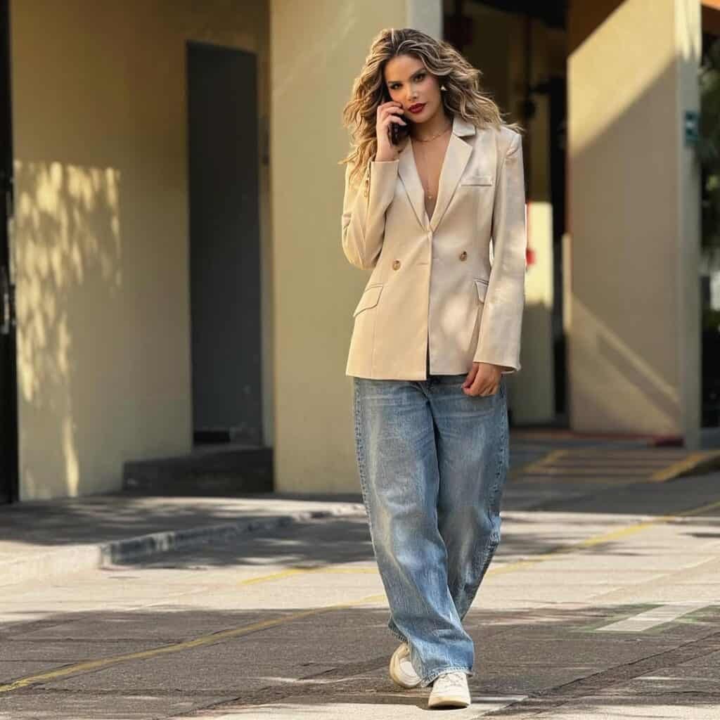 Woman talking on phone wearing a beige blazer paired with jeans, a chic blazer outfit look.

