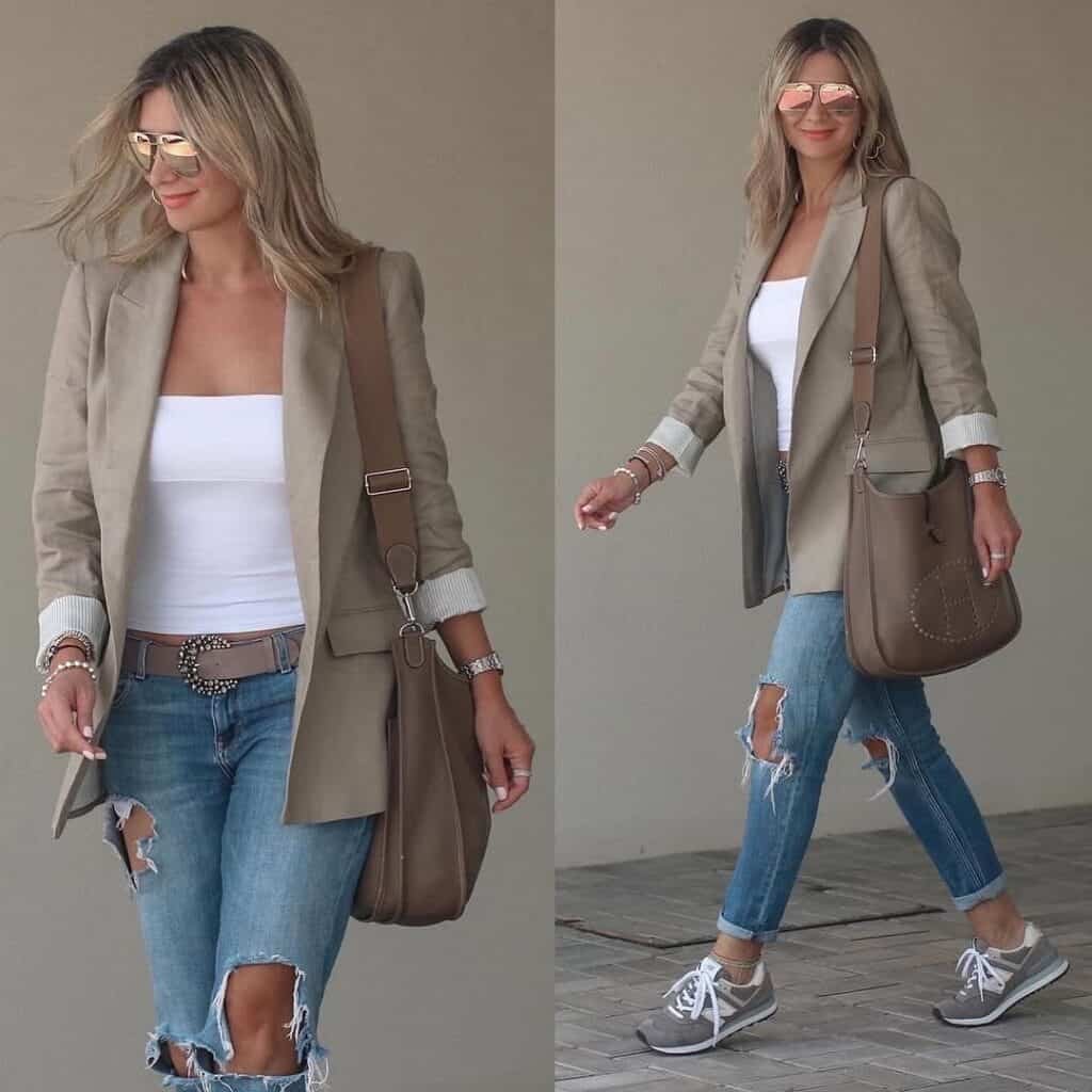 Casual blazer outfit featuring a woman in a beige blazer over a white top and ripped jeans, accessorized with reflective sunglasses and a brown bag.