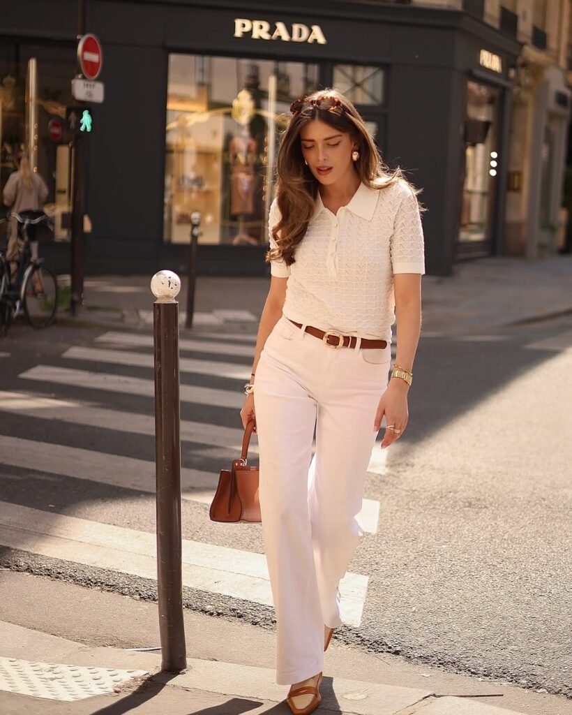  Elegant woman in all-white outfit in front of Prada store – old money outfits that reflect quiet luxury fashion.