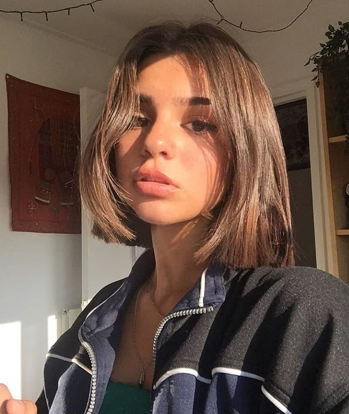 Cute Hairstyles for Short Hair featuring a soft blunt bob with natural shine and middle part, styled with a sporty zip-up top.