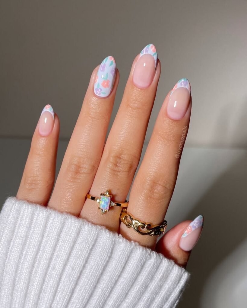 Spring Nail Ideas with pastel floral French tips featuring pink, purple, and blue flowers on a nude base.
