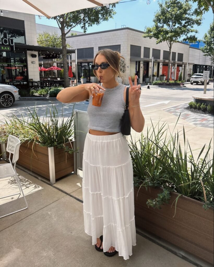 Relaxed Summer Outfits style with a gray crop tank and a tiered white maxi skirt, perfect for a casual day out with iced coffee.

