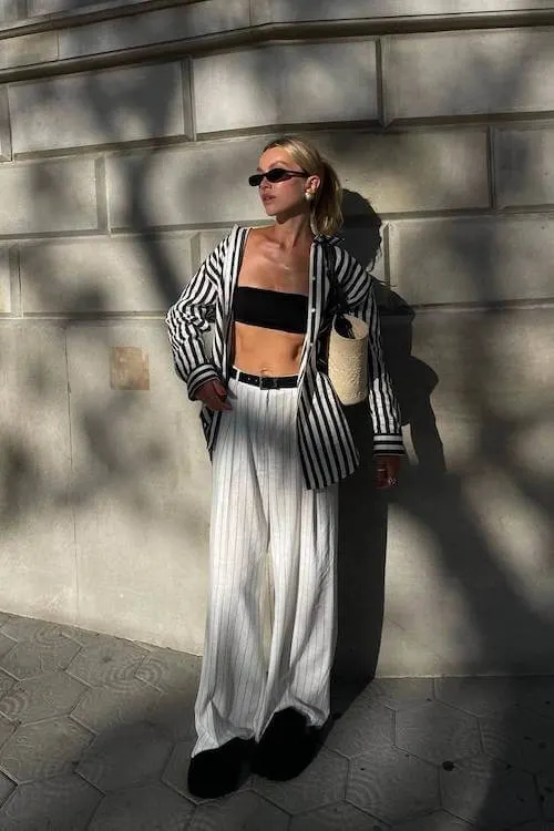 Chic Summer Vacation Outfit featuring a black bandeau top, striped oversized blazer, and wide-leg white striped pants for a modern, relaxed vibe.