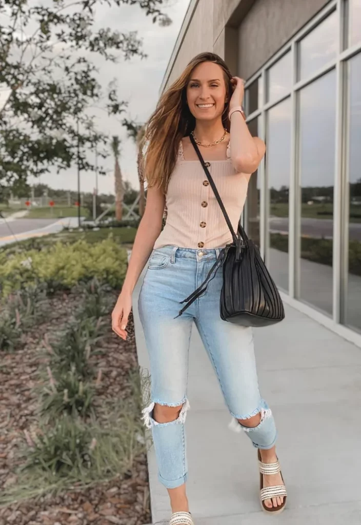 Woman wearing a sleeveless beige buttoned top with ripped skinny jeans and flat sandals—a casual summer outfit, though not typically modest.