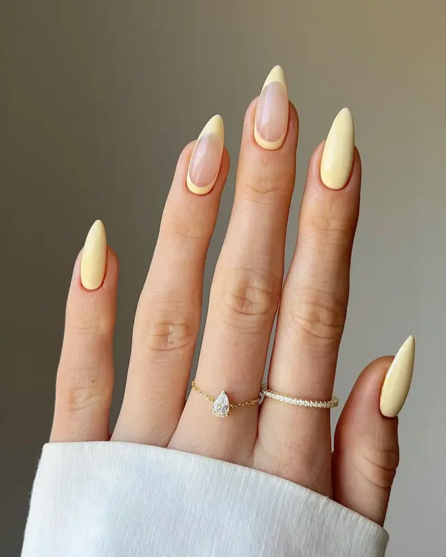 Spring Nail Ideas with soft yellow almond-shaped French tips and a clean nude center, perfect for a minimalist look.