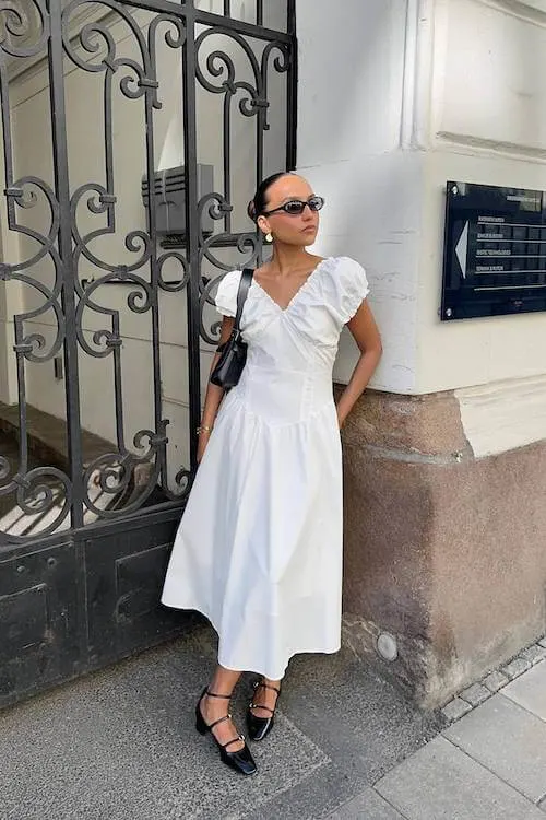 Elegant Summer Vacation Outfit with a white puff-sleeve midi dress, black Mary Jane shoes, and statement earrings for a romantic touch.