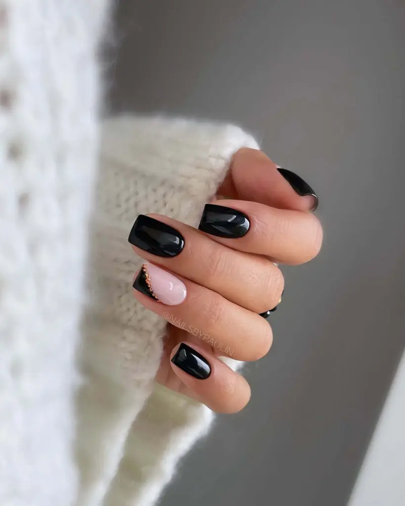 Glossy black and nude nail ideas with gold beads for a bold and modern contrast.