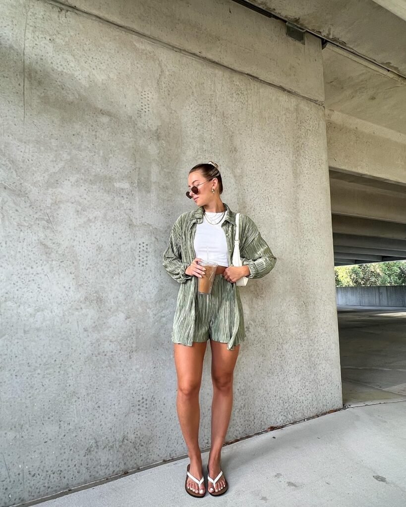 Coordinated Summer Outfits with a relaxed green striped set—shorts and an open shirt over a white tank, completed with flip-flops and iced coffee.