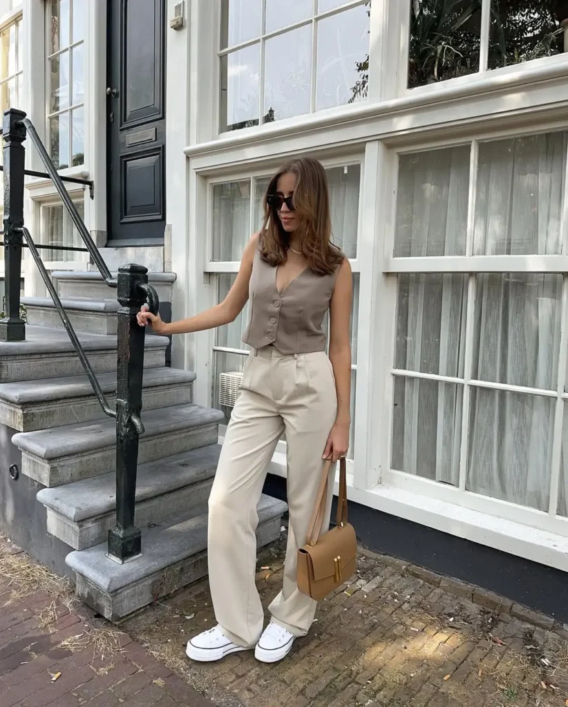 Refined Casual Summer Outfits with a taupe vest top and beige high-waisted trousers, accessorized with white sneakers, dark sunglasses, and a structured tan handbag.