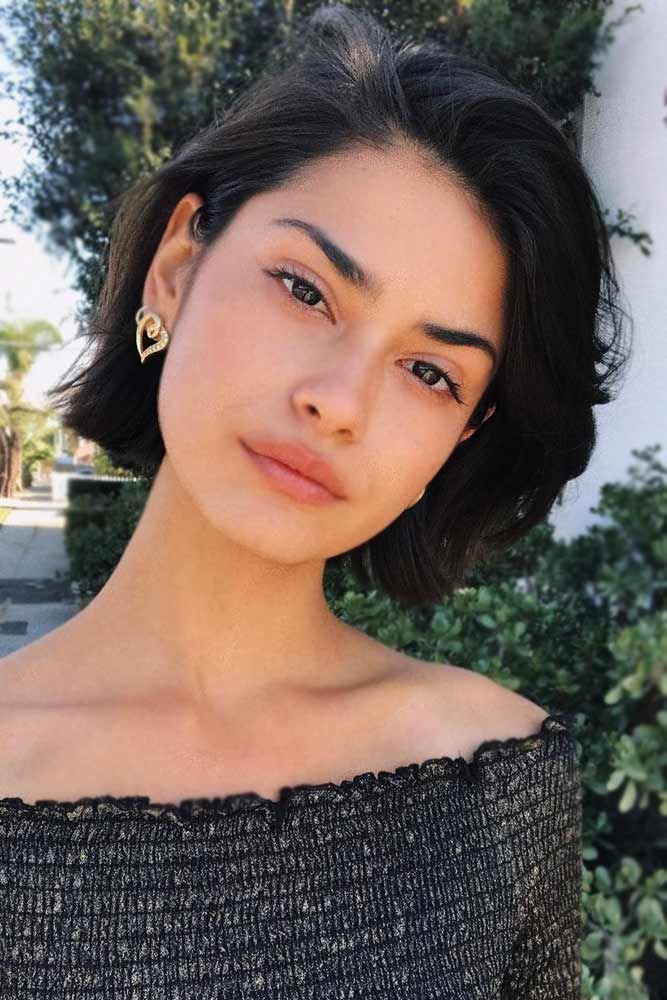 Cute Hairstyles for Short Hair with a sleek side-parted bob, tucked behind one ear and accessorized with bold heart-shaped earrings.