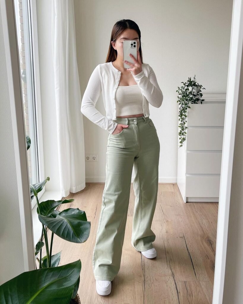 Minimalist wide leg pants outfit with pastel green high-waisted pants and a white crop top layered with a cardigan.
