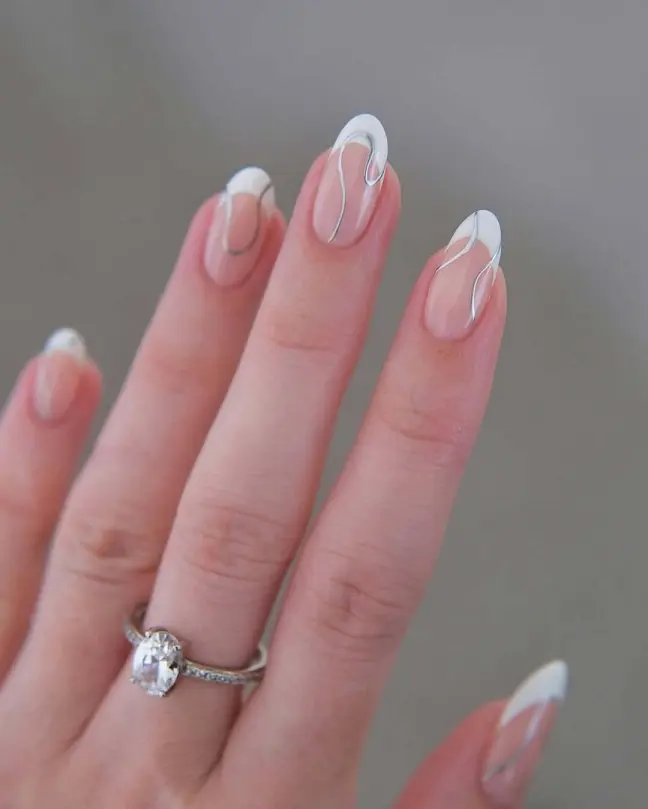 Minimalist white swirl nail ideas on natural pink almond-shaped nails, perfect for a chic aesthetic.