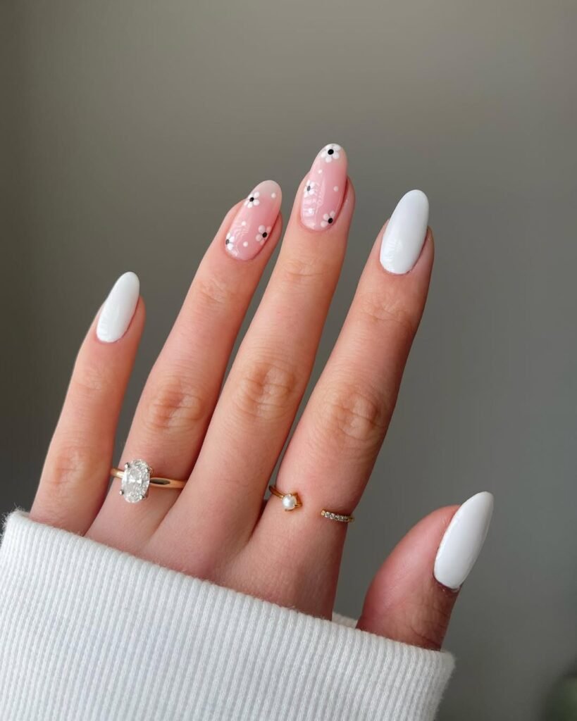 Spring Nail Ideas with clean white polish and soft pink base decorated with simple black and white floral dots.