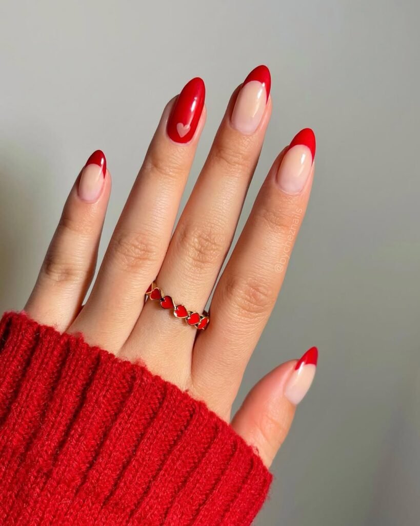 Bold red tip nail ideas with a hidden heart accent for a fun Valentine’s Day design.