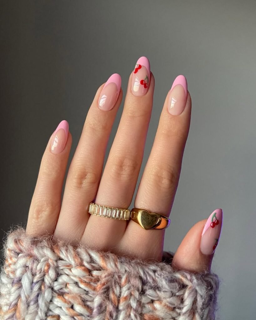 Spring Nail Ideas with pink French tips and playful cherry fruit nail art on a natural pink background.